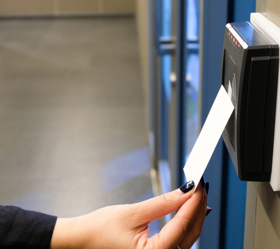 Women hand reaching to use RFID key card to access to office building area and workspace. In building security only for authorized person